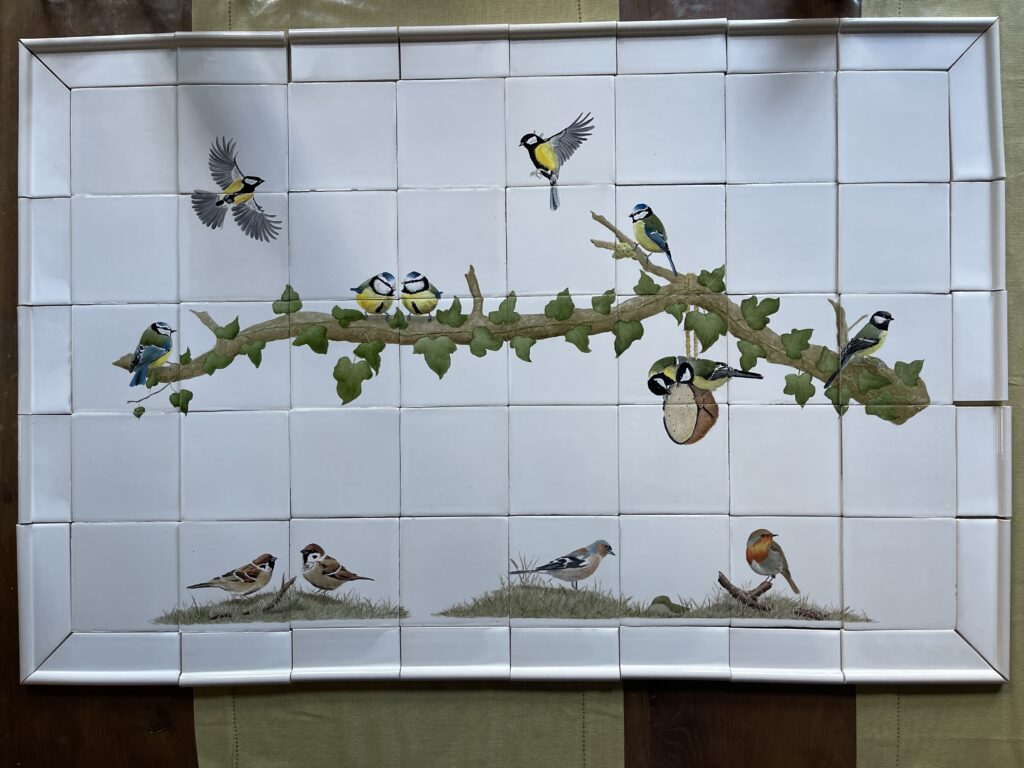 Tegeltableau met meesjes en musjes op een tak met sierrandjes